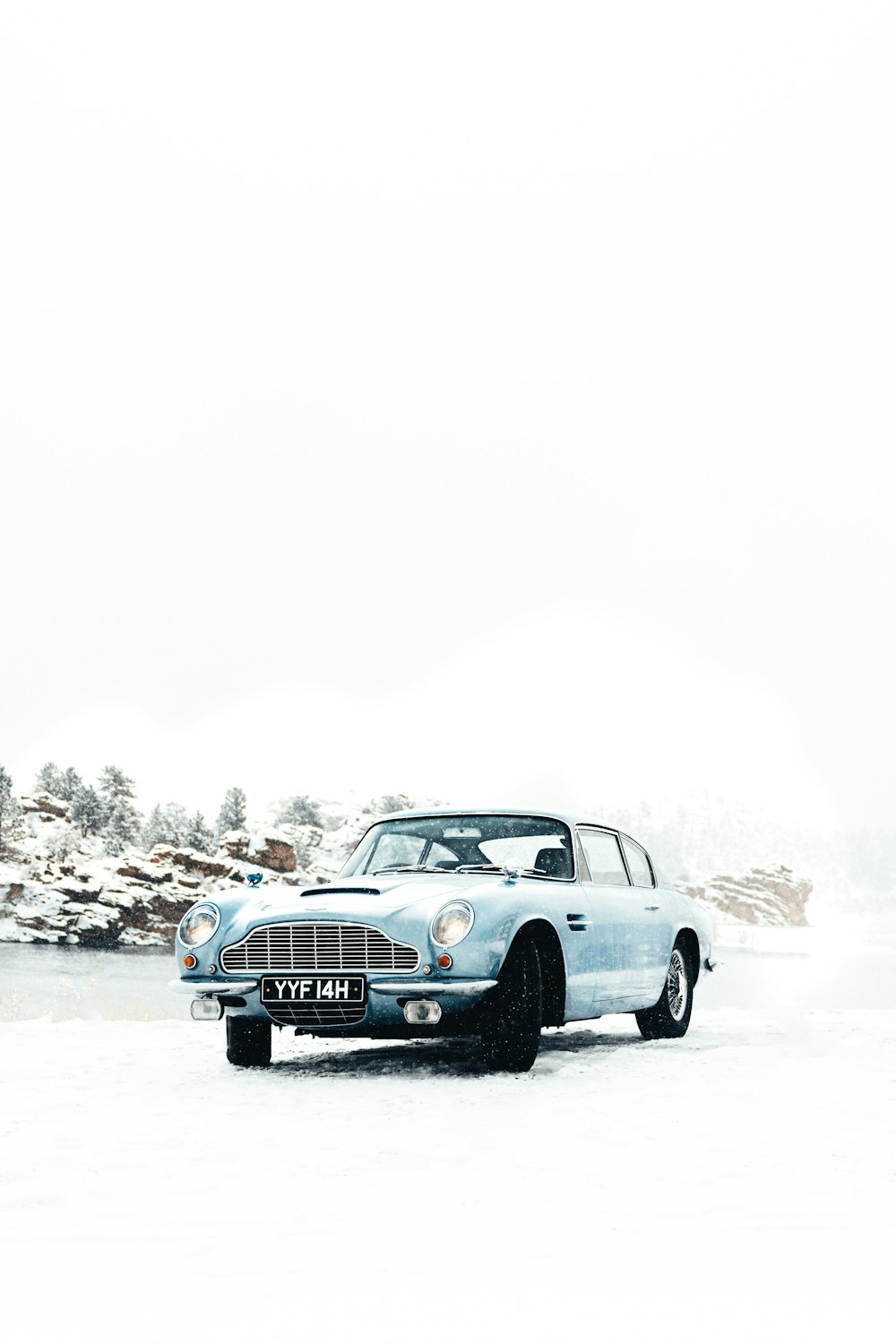 Une voiture bleue est garée dans la neige