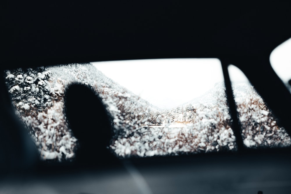 a view of a snowy mountain through a car window