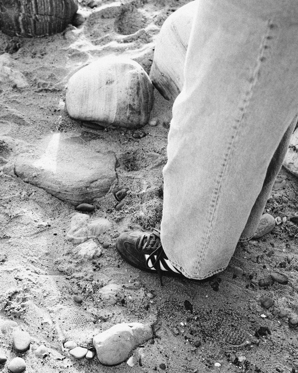 a black and white photo of a person's feet in the sand