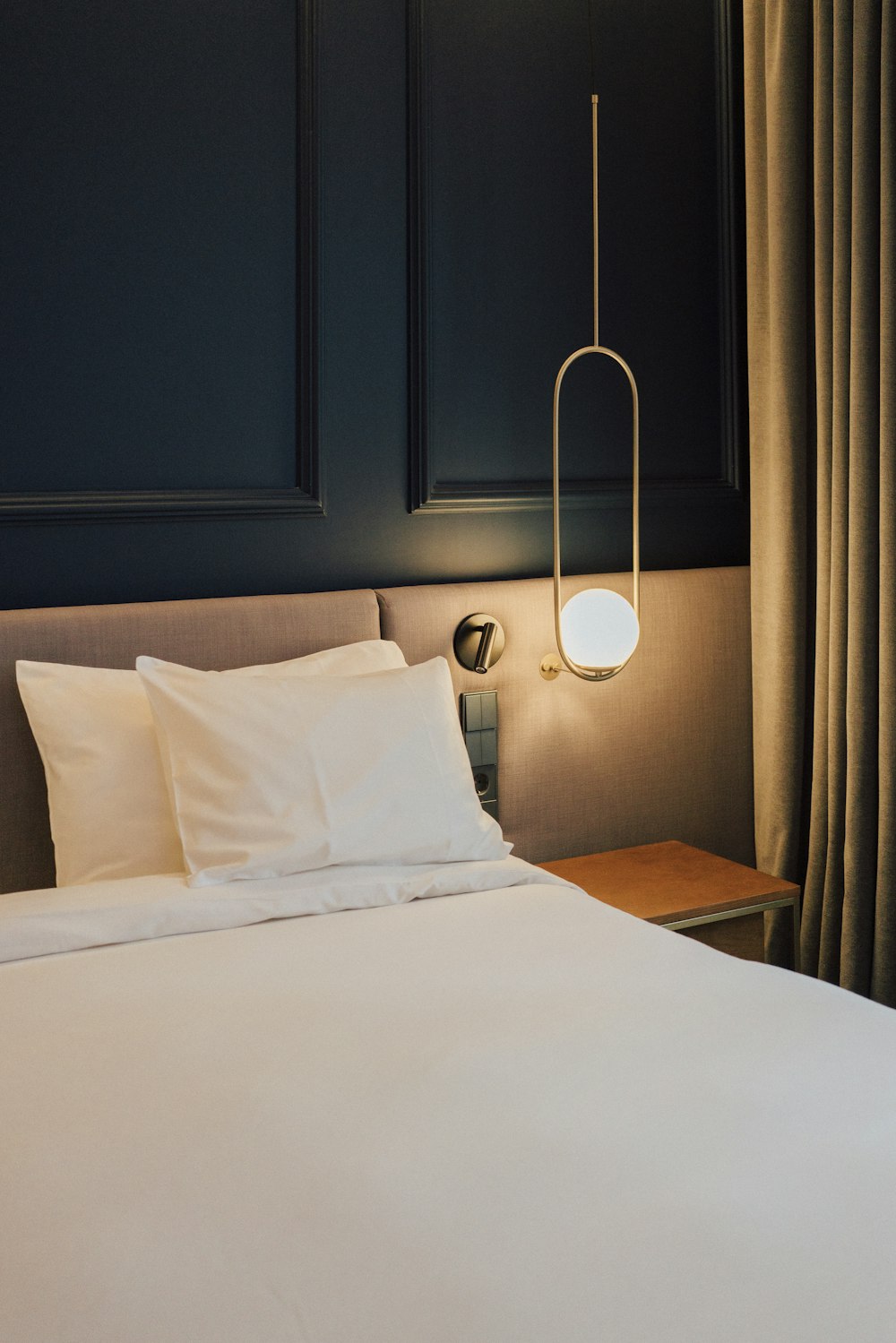 a bed with white sheets and pillows in a room