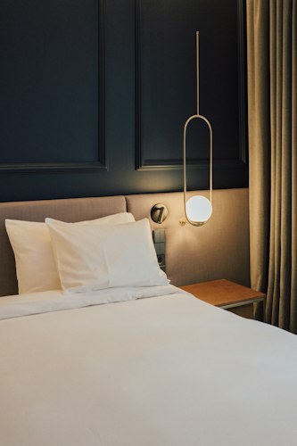 Close-up of a smartwatch displaying sleep tracking data on a nightstand beside a hotel bed
