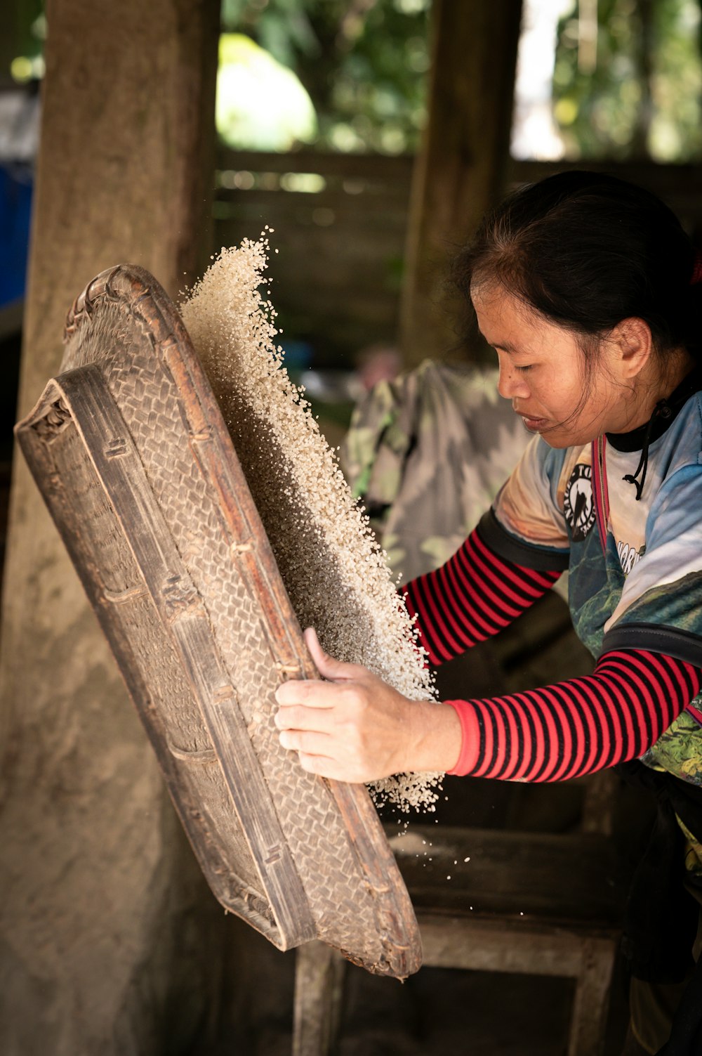 a woman in a red and white striped shirt working on a piece of wood