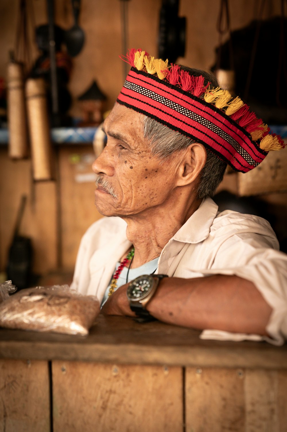 a man wearing a colorful headdress sitting at a counter