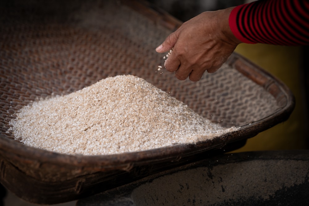 a person scooping rice out of a basket