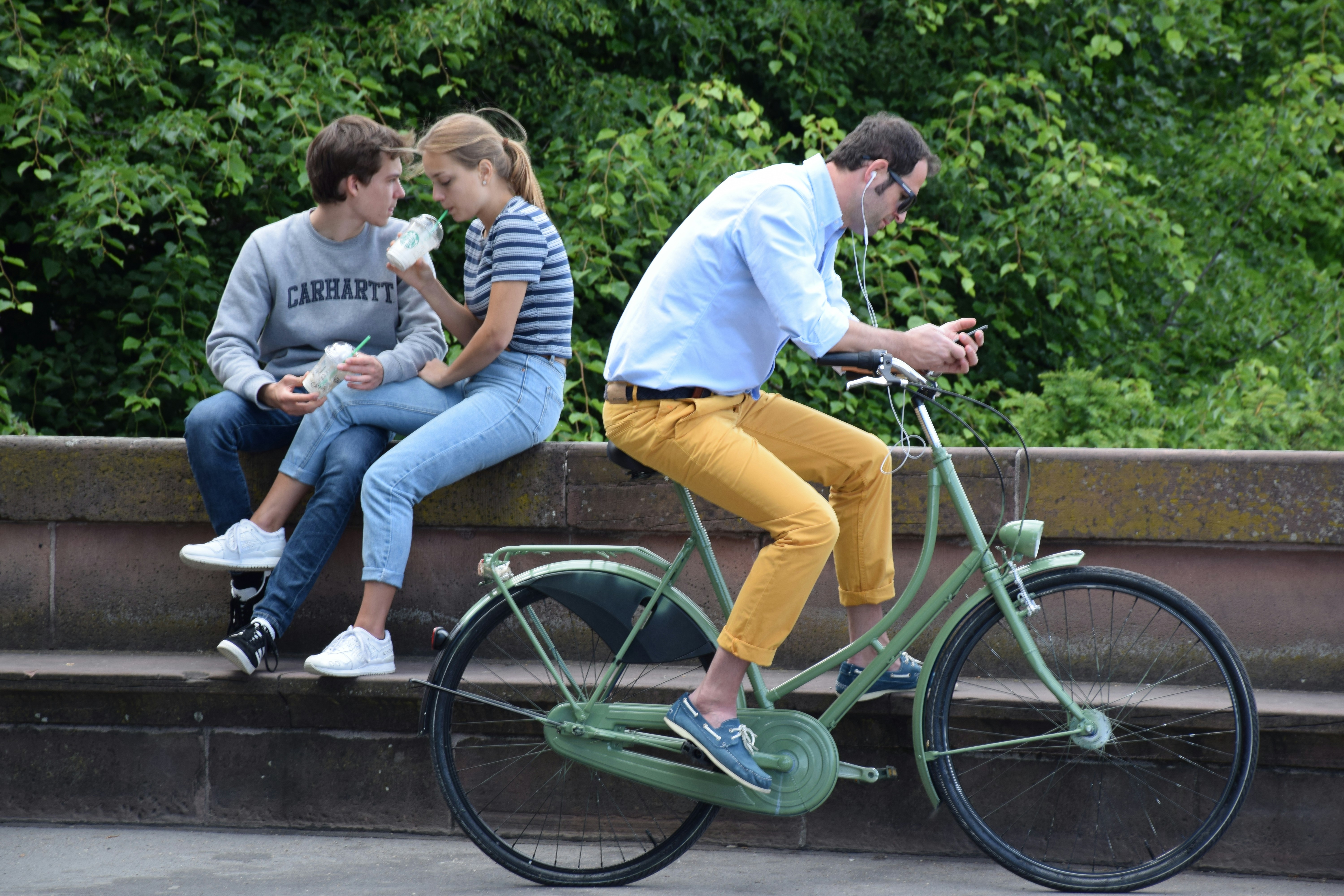 three people sitting on a bench on a bike