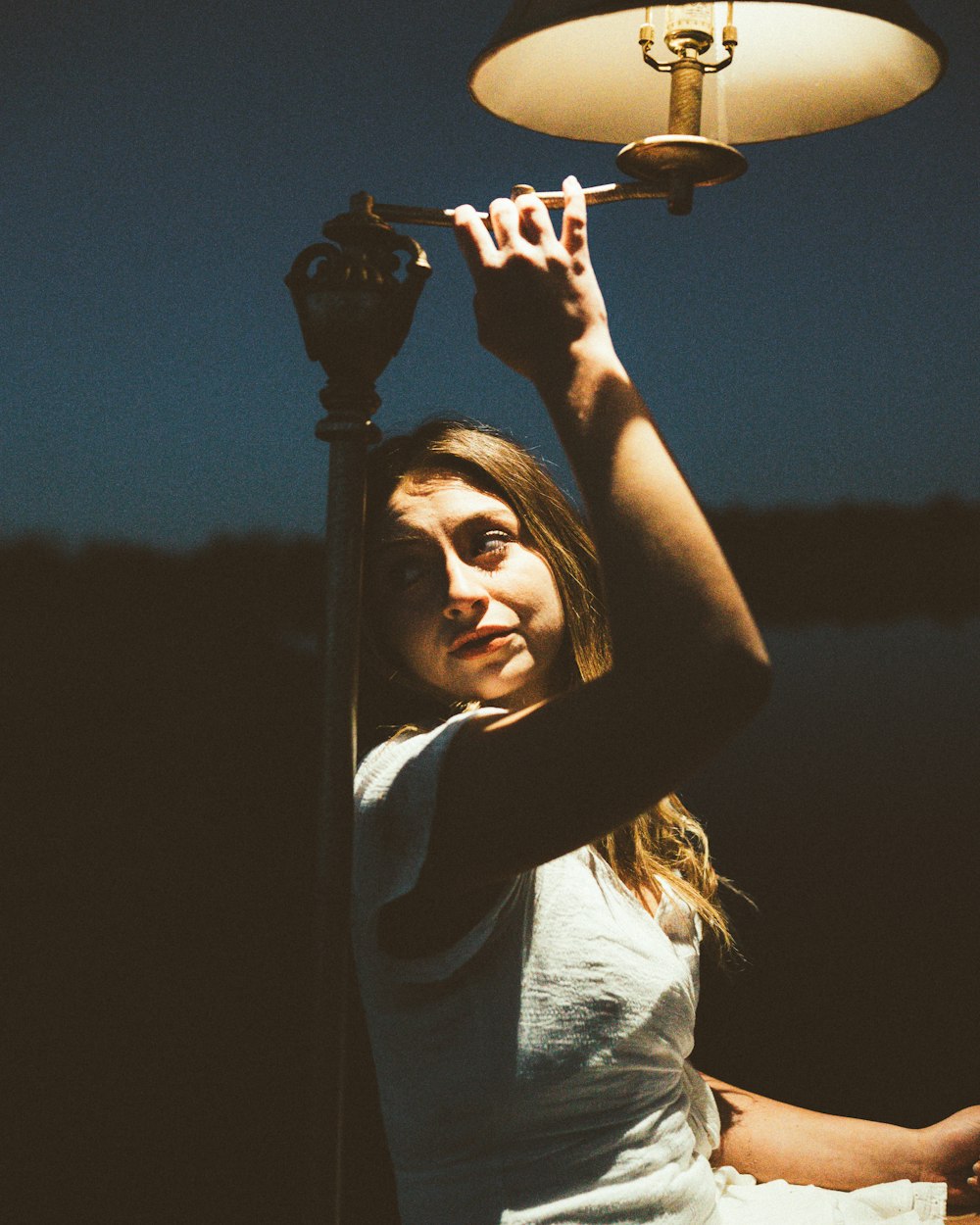 a woman is holding a light above her head