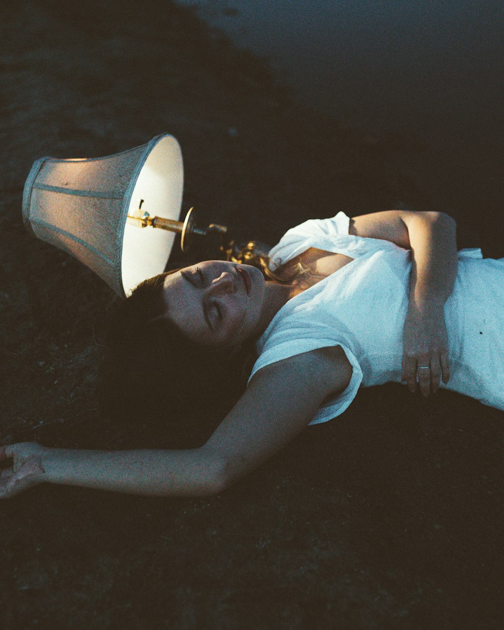una donna sdraiata a terra con una lampada in testa