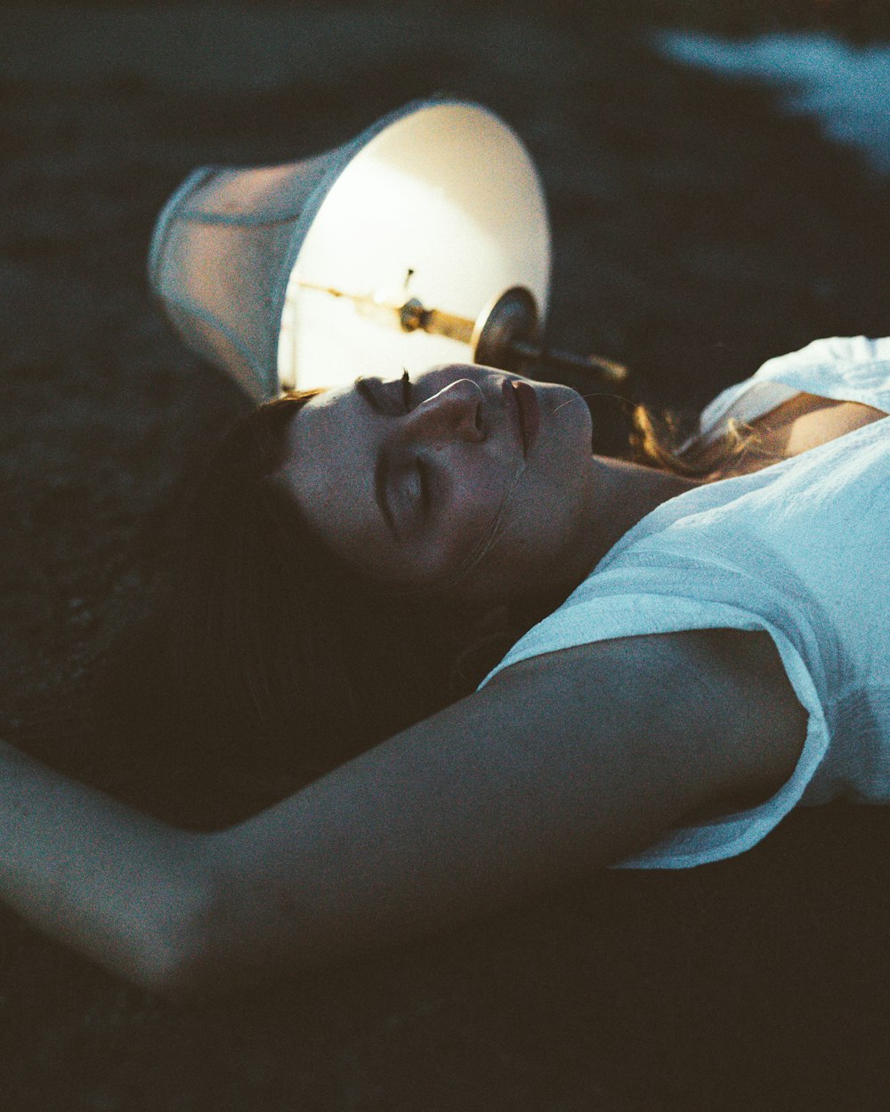 a woman laying on the ground with a light on her head