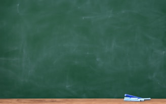 a blackboard with a chalkboard and two pens on it