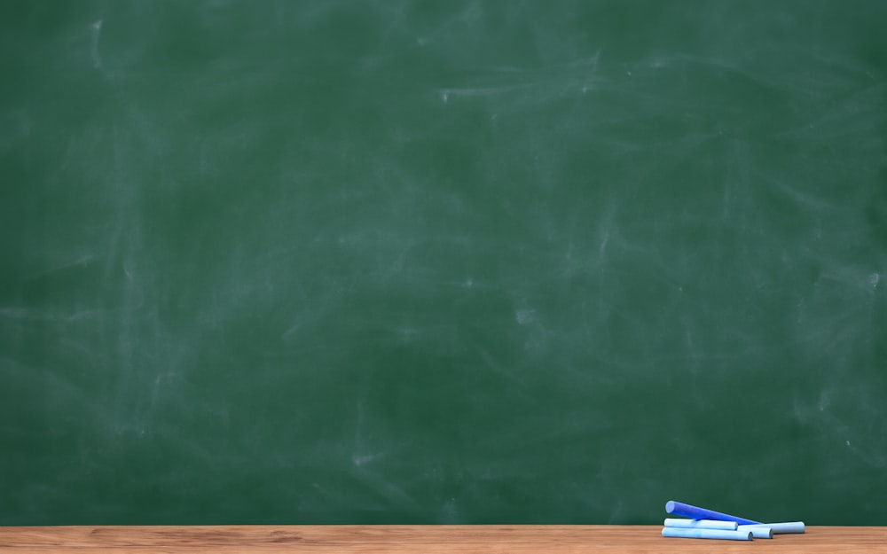 a blackboard with a chalkboard and two pens on it