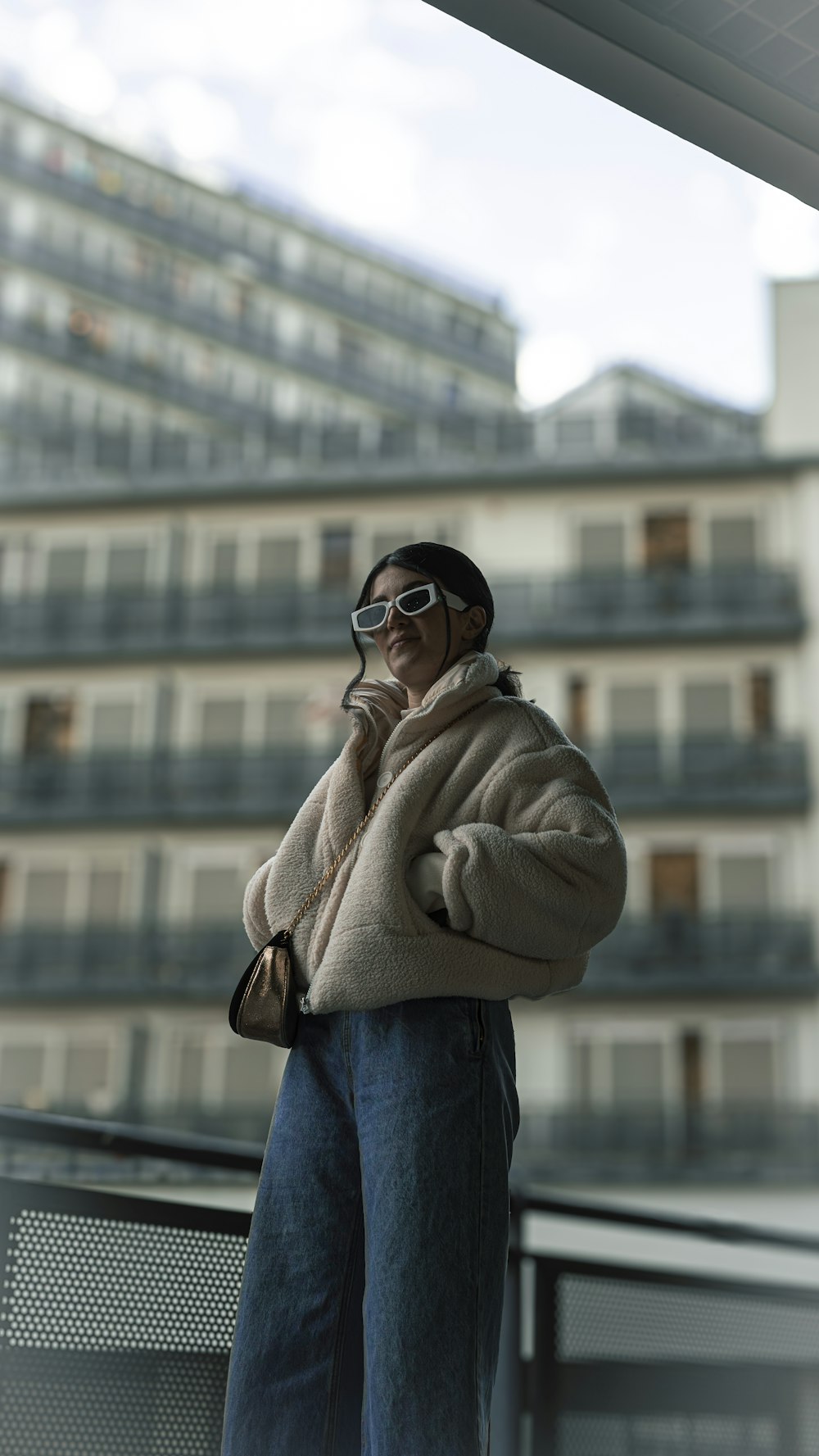 a man standing on a balcony talking on a cell phone