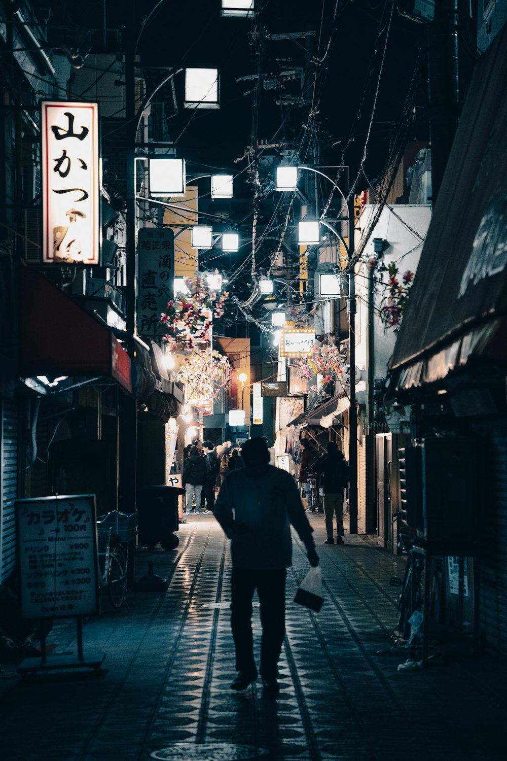 a man walking down a street at night