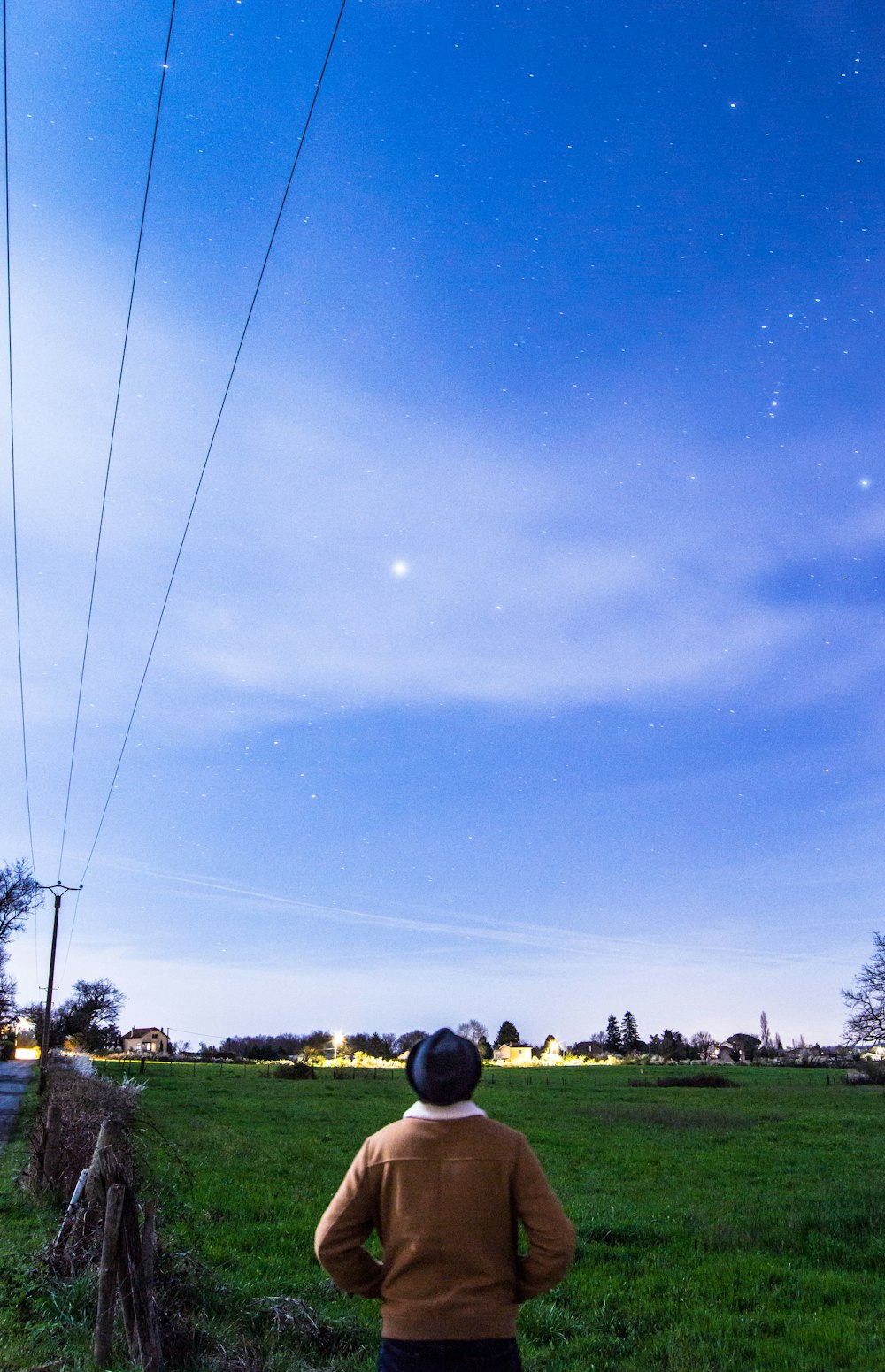 a person standing in a field flying a kite