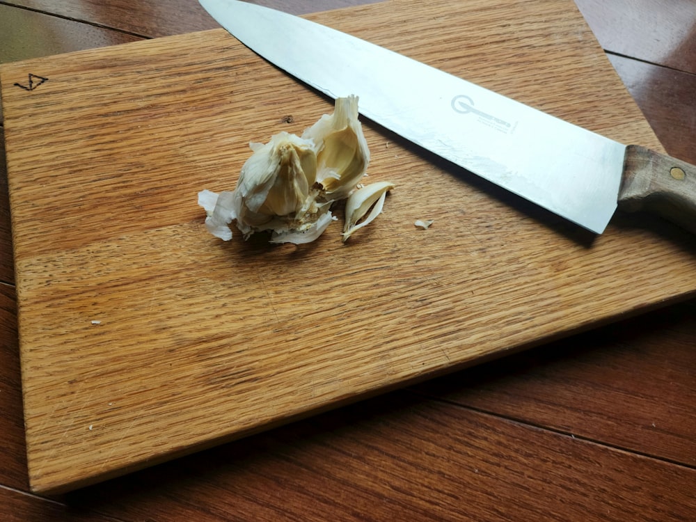 a knife on a cutting board with some food on it