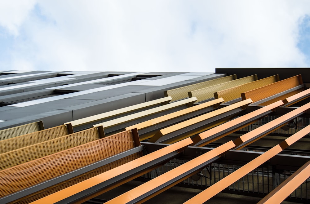 a row of wooden benches sitting next to a tall building