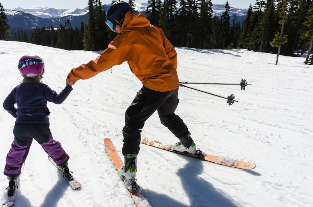 a woman teaching a child how to ski