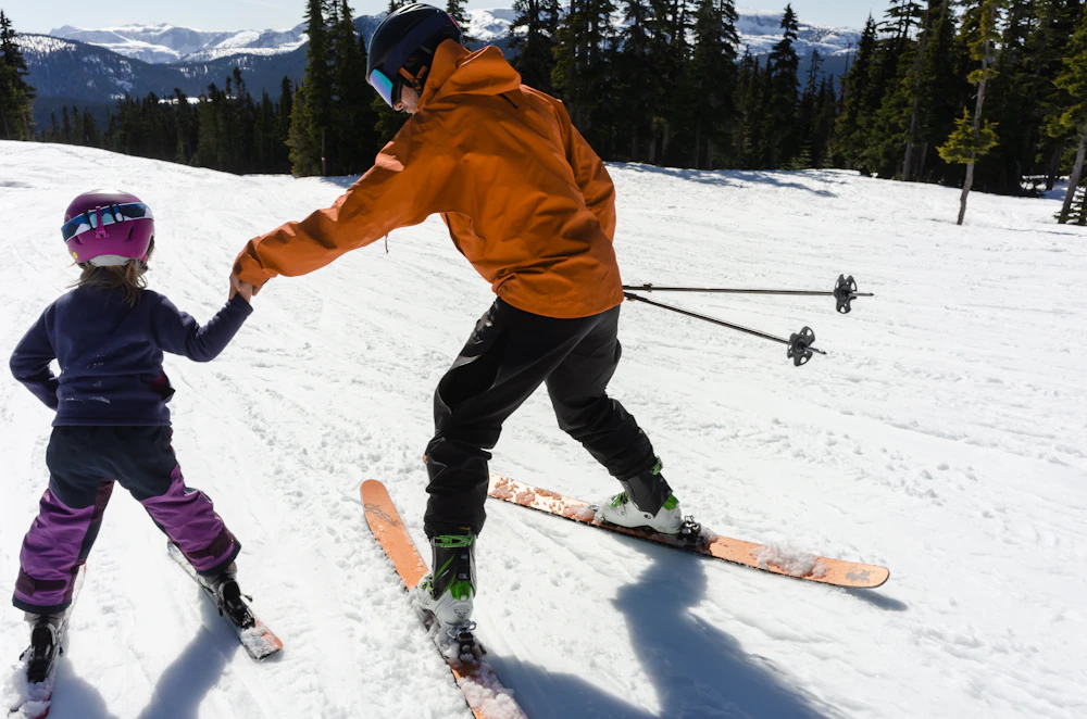 An instructor helping a child ski