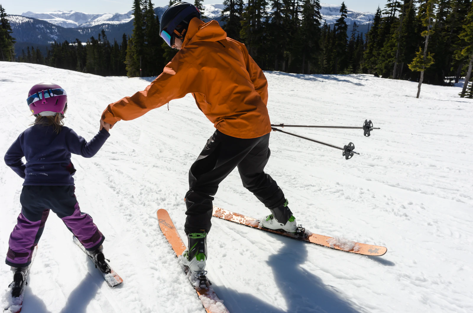 An instructor teaching a child to ski