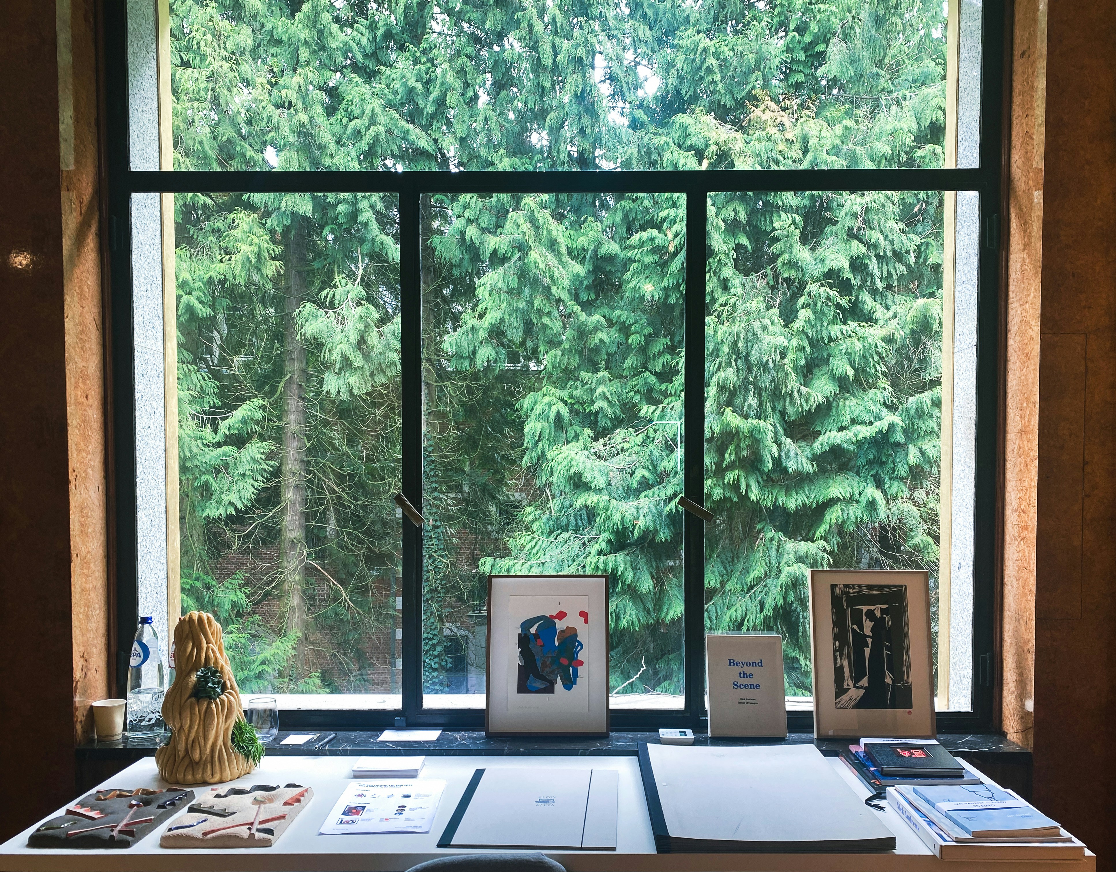 a desk in front of a window with pictures on it