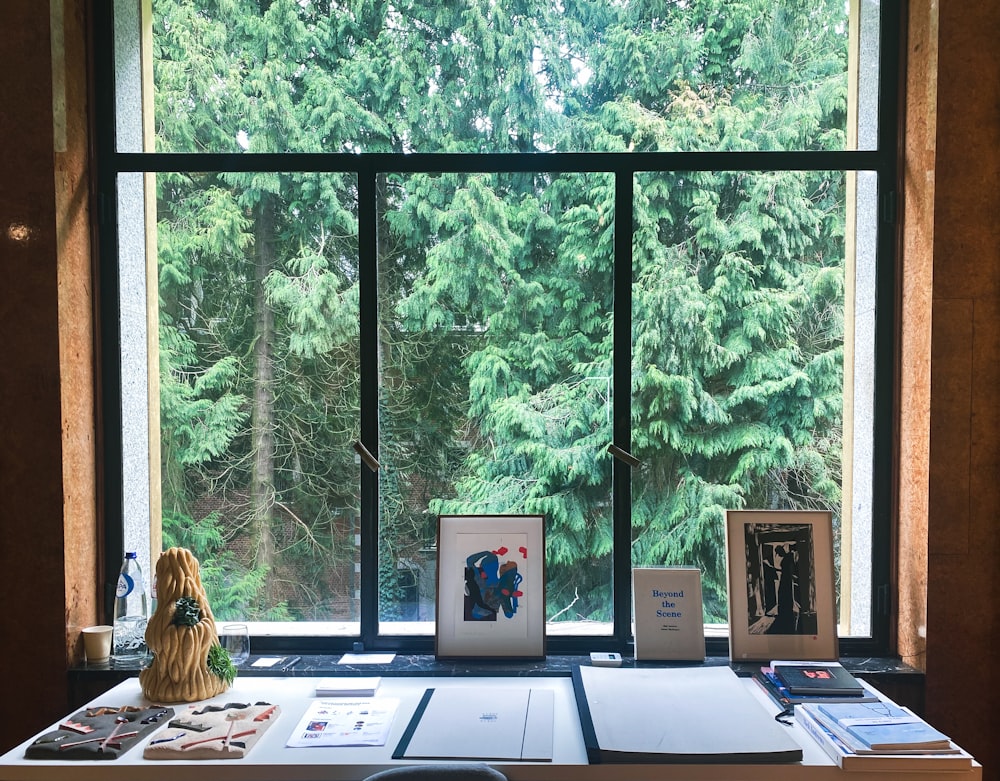 a desk in front of a window with pictures on it