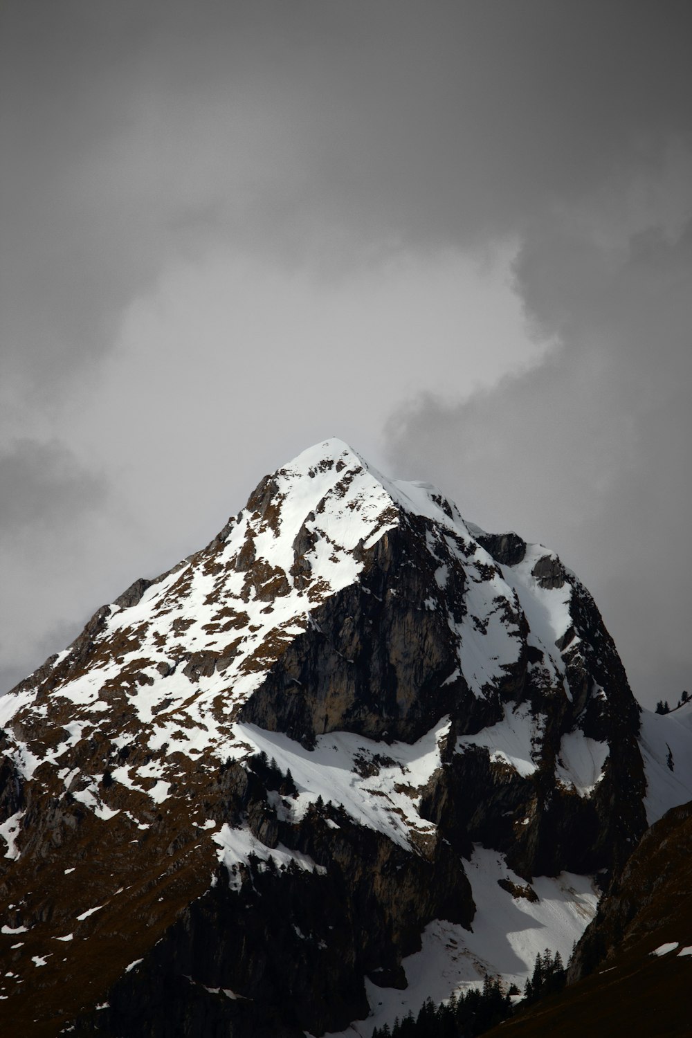 a snow covered mountain under a cloudy sky