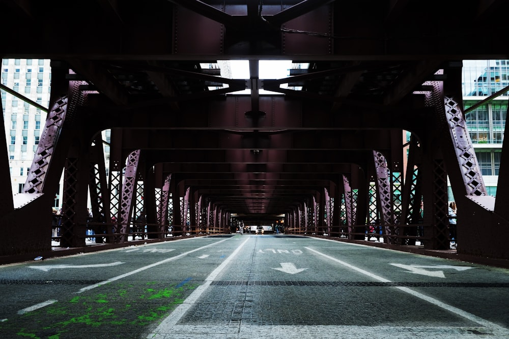 an empty street under a bridge in a city