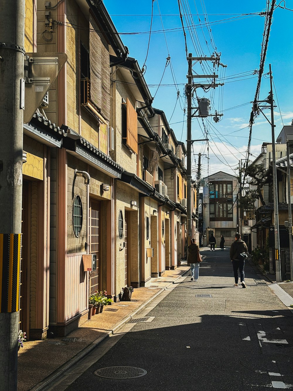 a man walking down a street next to tall buildings