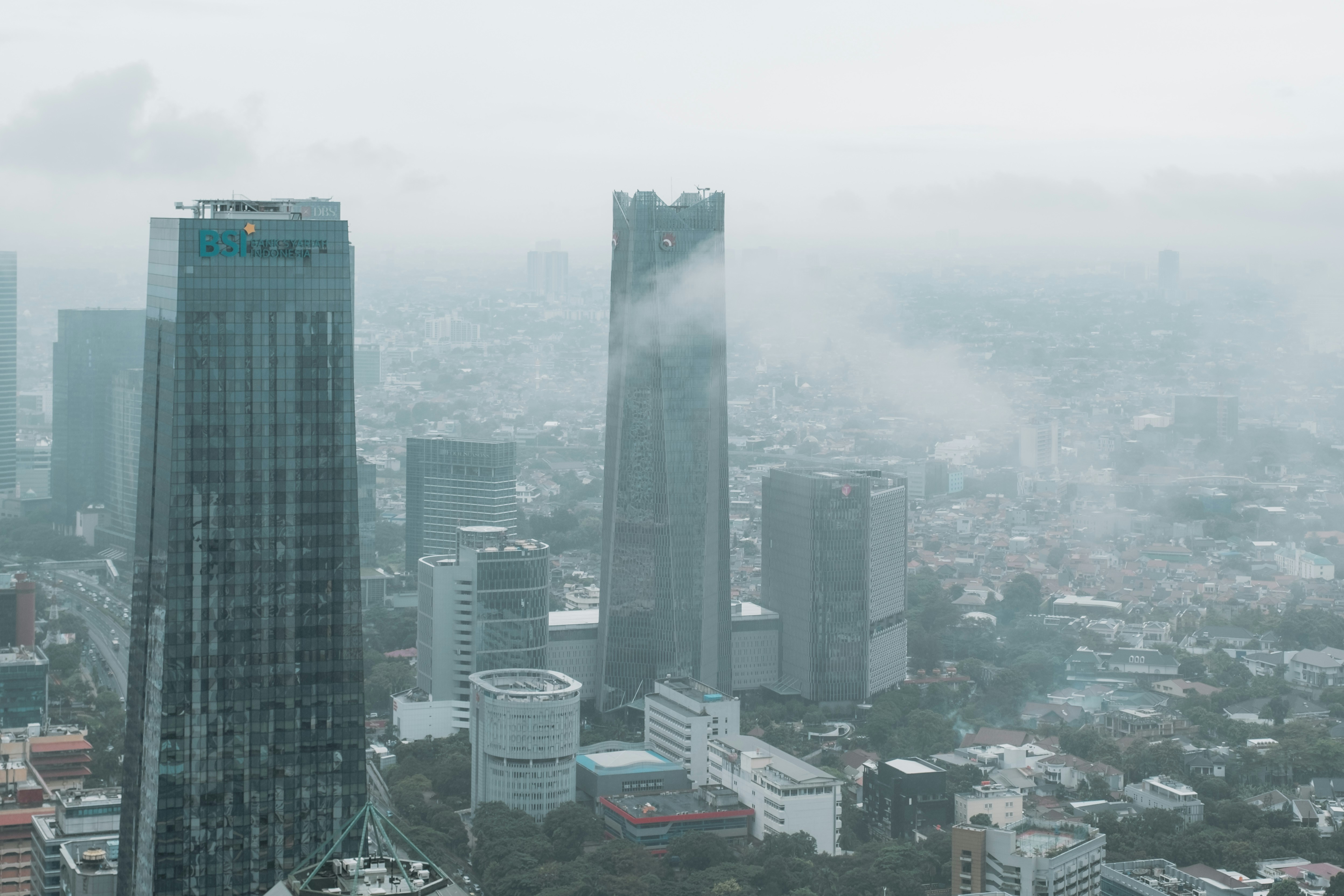 pemandangan kota berkabut dengan gedung-gedung tinggi dan gedung pencakar langit
