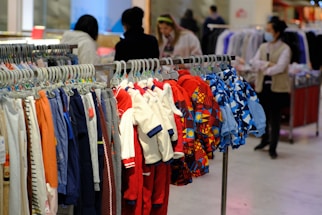 a bunch of clothes hanging on a rack in a store