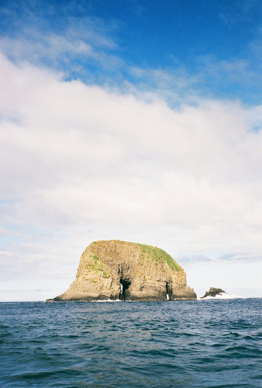 a large rock in the middle of the ocean