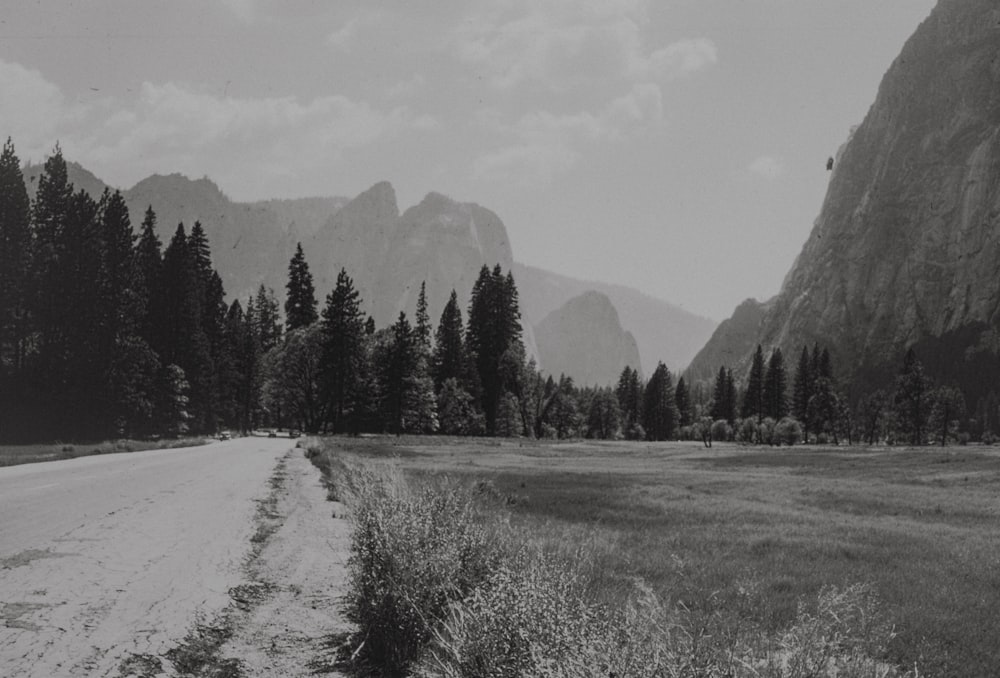 a black and white photo of a road in the mountains