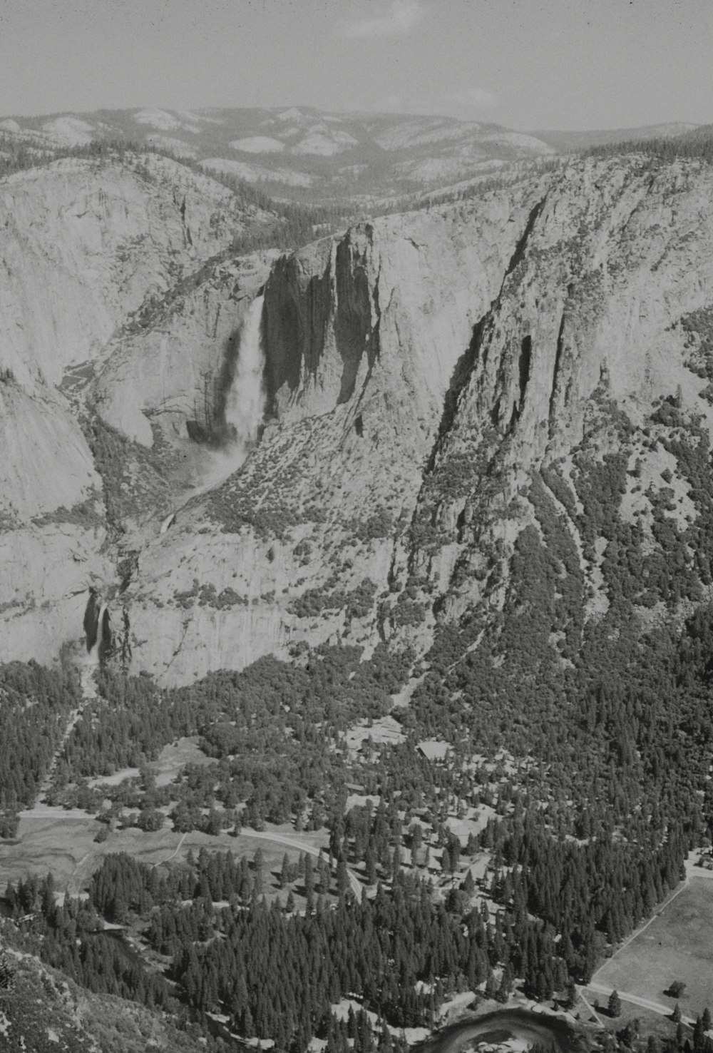 a black and white photo of a valley and mountains
