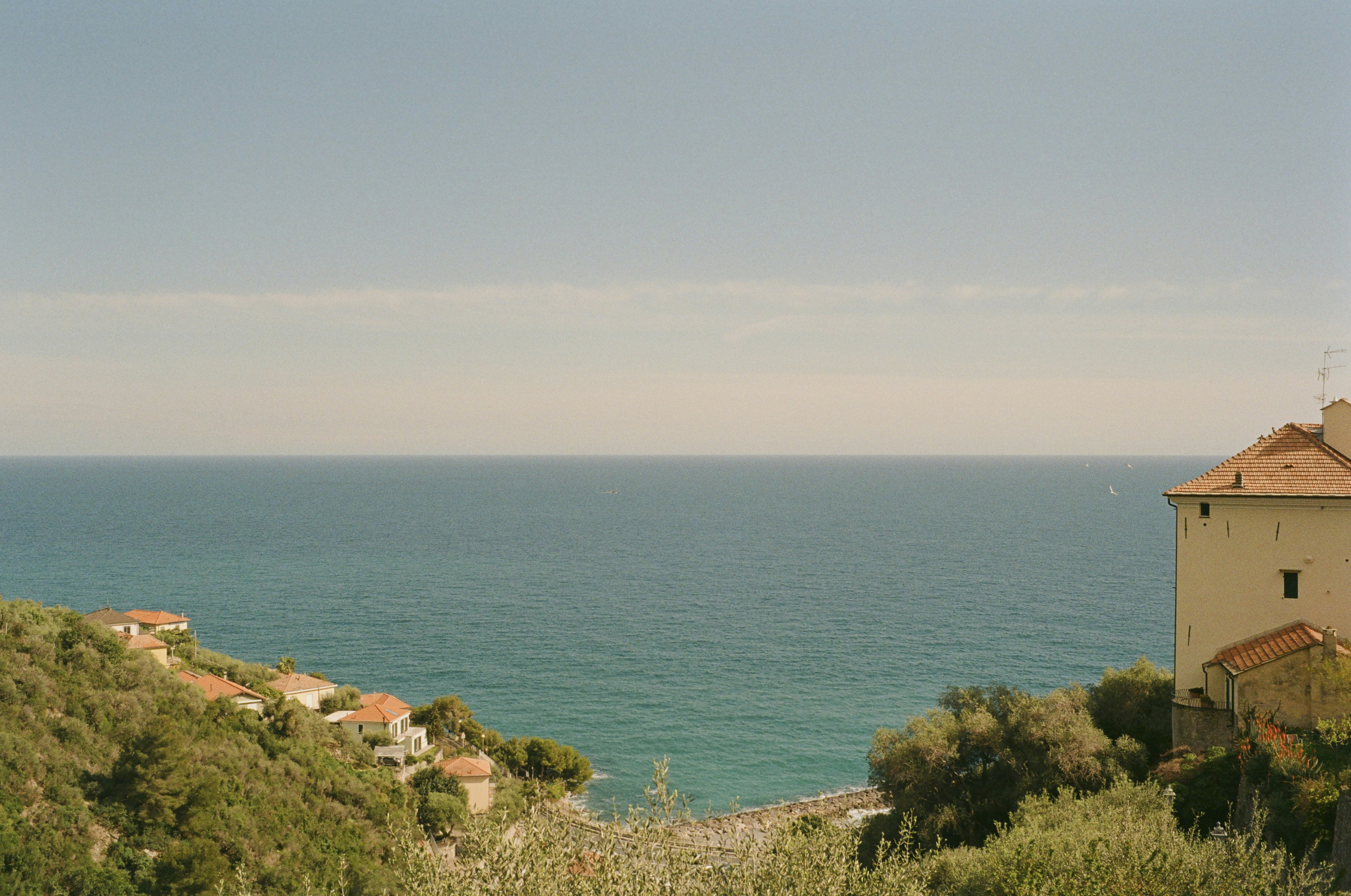 a view of a body of water from a hill, Seaside roof terrace with view to the ligurian sea. Leica M6 (1987), Summilux-M 1.4 35mm (1983). Hi-Res analog scan by www.urbanfilmlab.com – Kodak Gold 200 (expired)