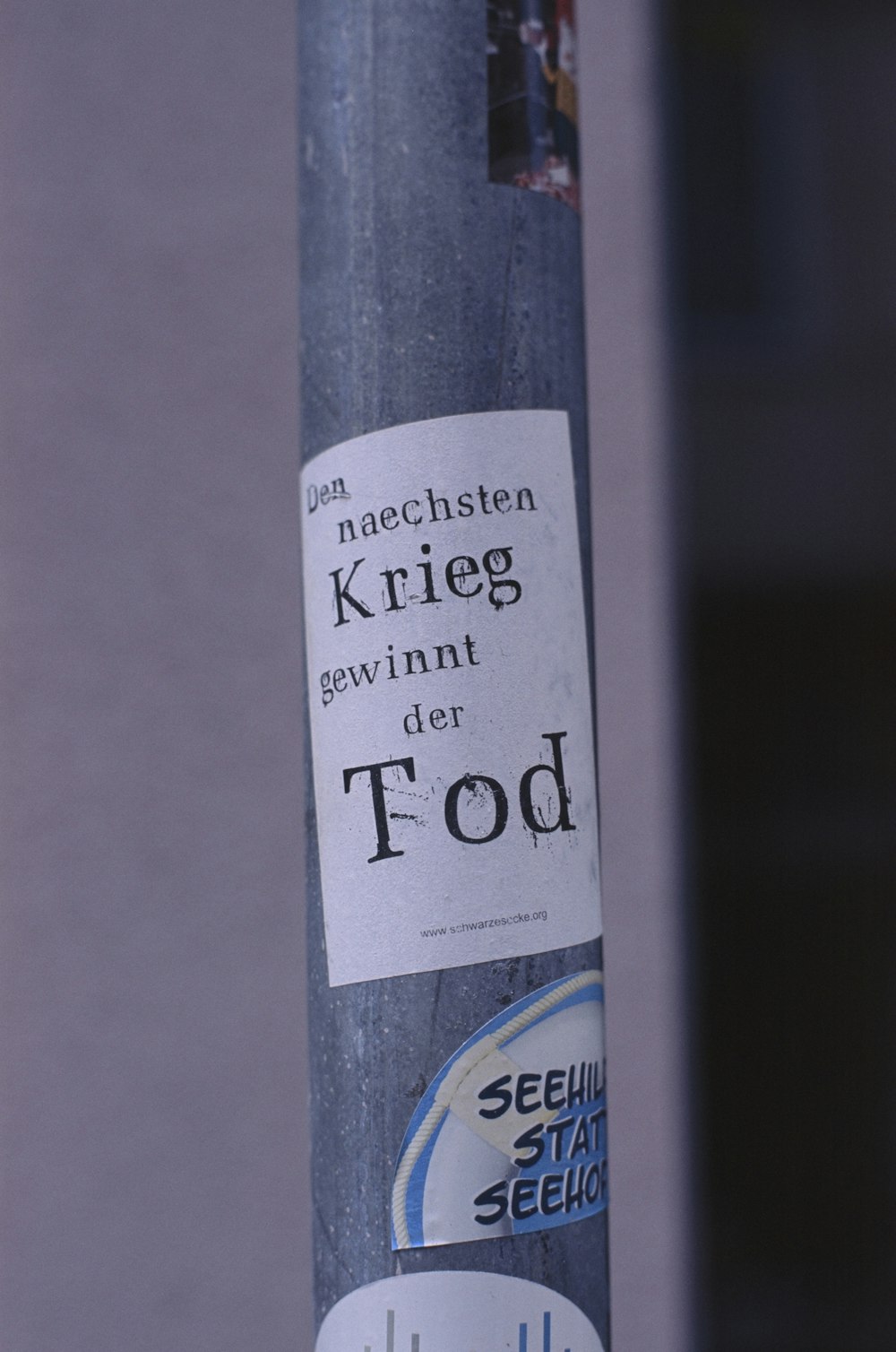 a sticker on a pole with a message on it