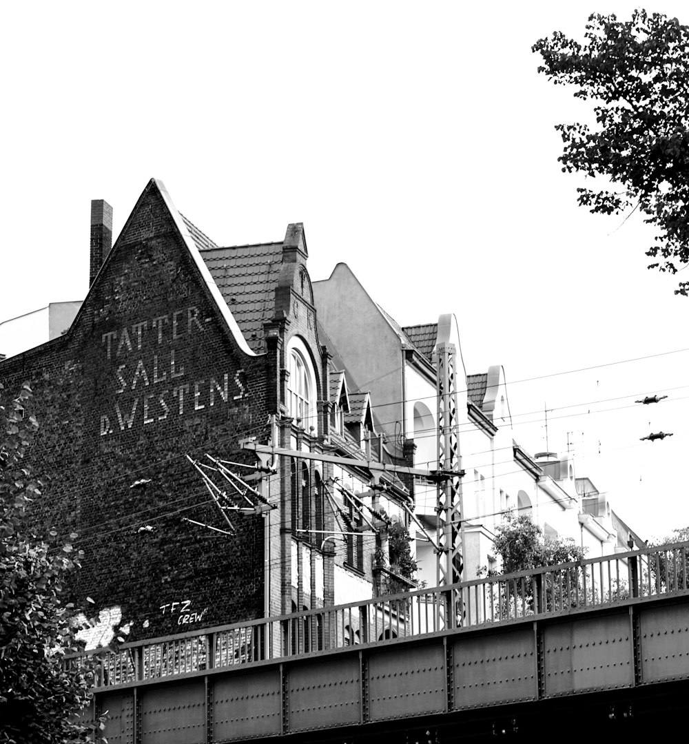 a black and white photo of a building on a bridge