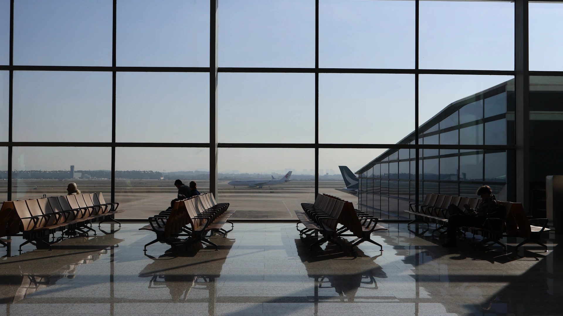 a couple of people sitting in chairs in front of a window