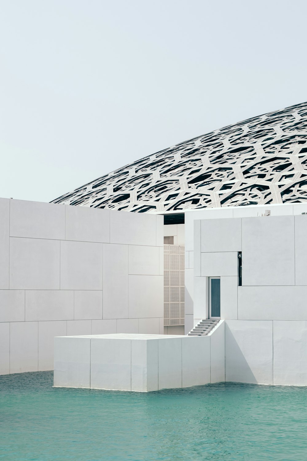 a large white building with a pool in front of it