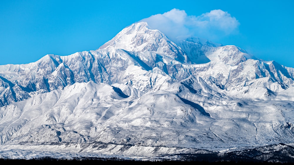 ein schneebedeckter Berg mit blauem Himmel im Hintergrund