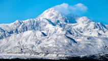 a snow covered mountain with a blue sky in the background