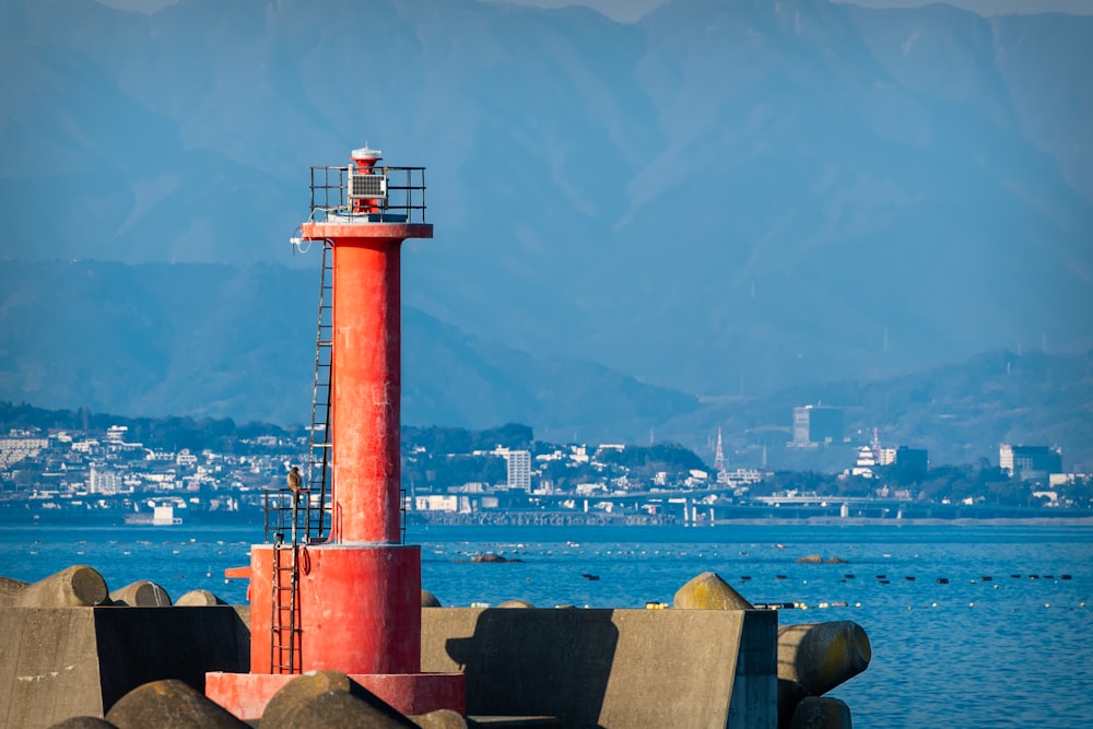 a red light house sitting on top of a pier