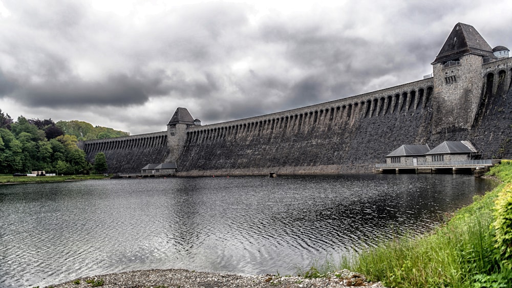 un grande edificio in mattoni seduto sulla riva di un fiume