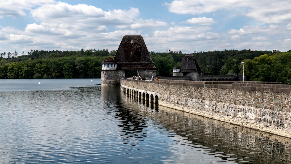 a large body of water next to a stone wall