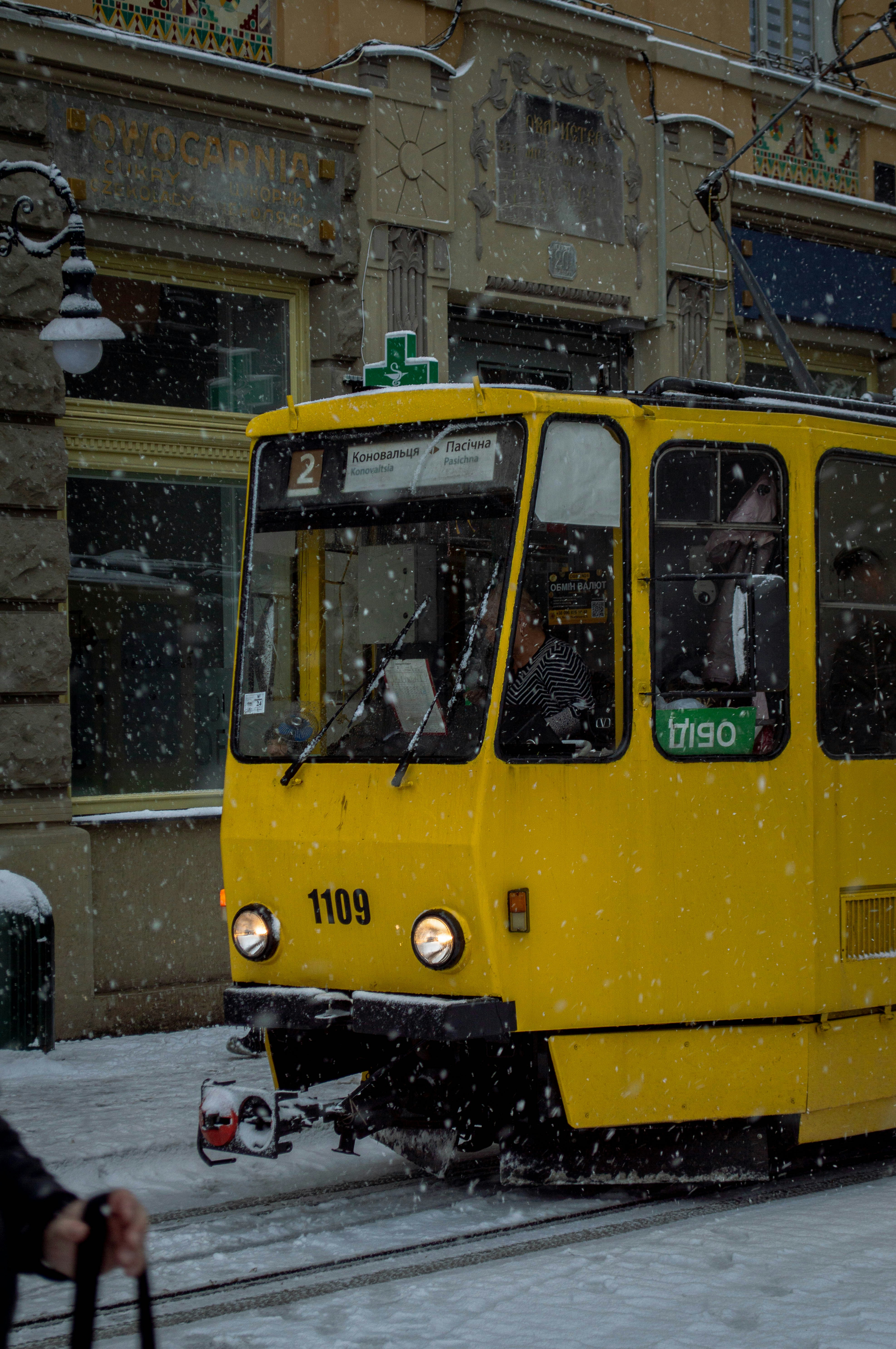 Ein gelber Bus fährt eine schneebedeckte Straße entlang
