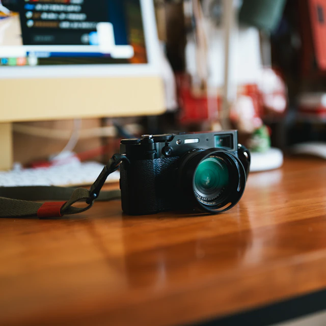 A compact camera sitting on top of a wooden desk