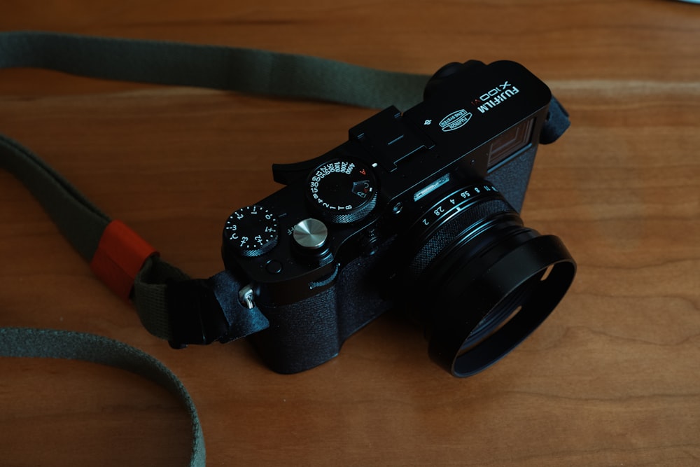 a black camera sitting on top of a wooden table