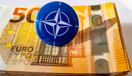 a blue button sitting on top of a pile of money