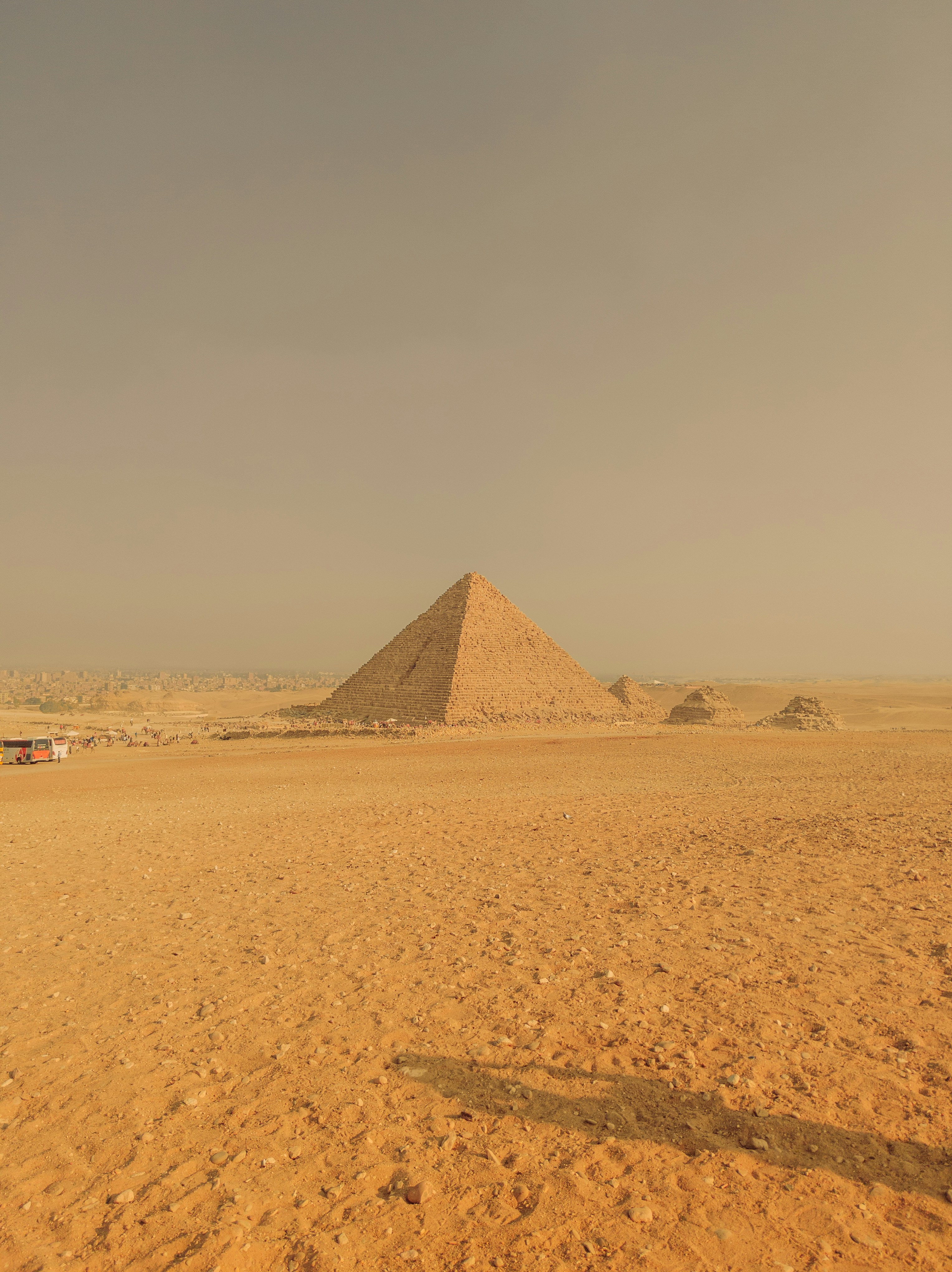 a man standing in front of a pyramid in the desert