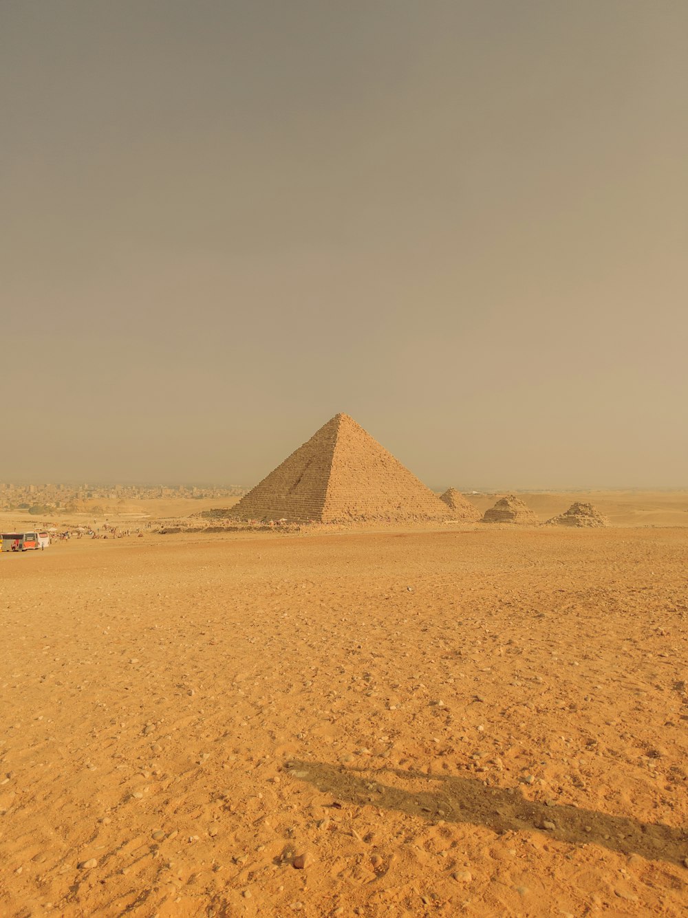 a man standing in front of a pyramid in the desert