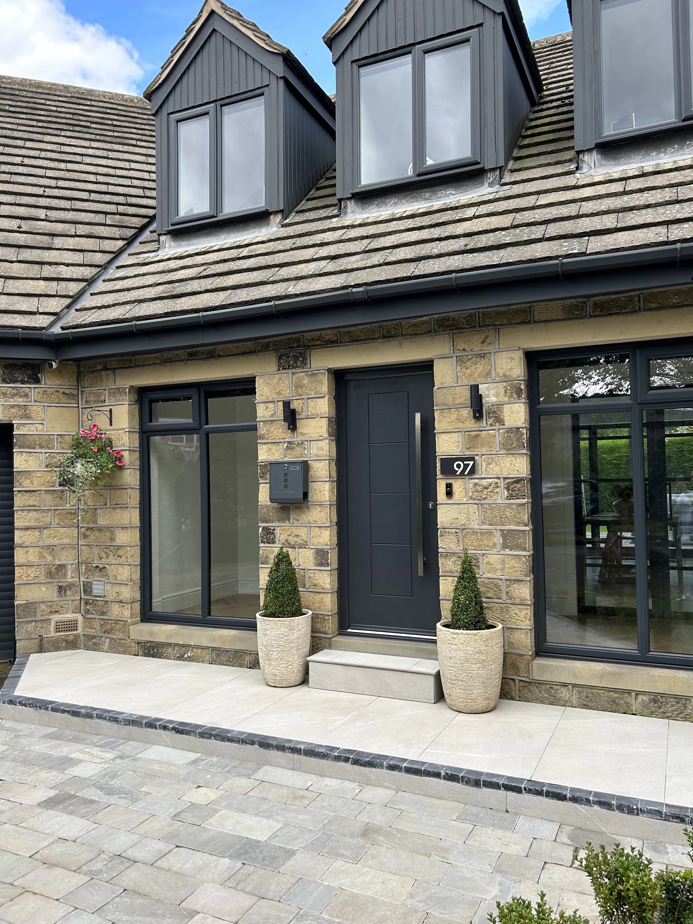 A stone house with a new block paved driveway