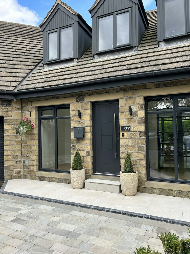 Stone house with grey block-paved drive